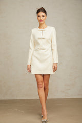 A short white tweed mini dress adorned with sparkling sequins featuring a fitted silhouette and delicate feminine details