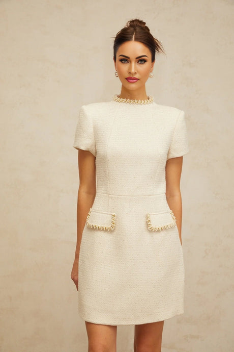 A short white tweed mini dress with embellishments named Jeanne featuring a fitted silhouette and textured fabric