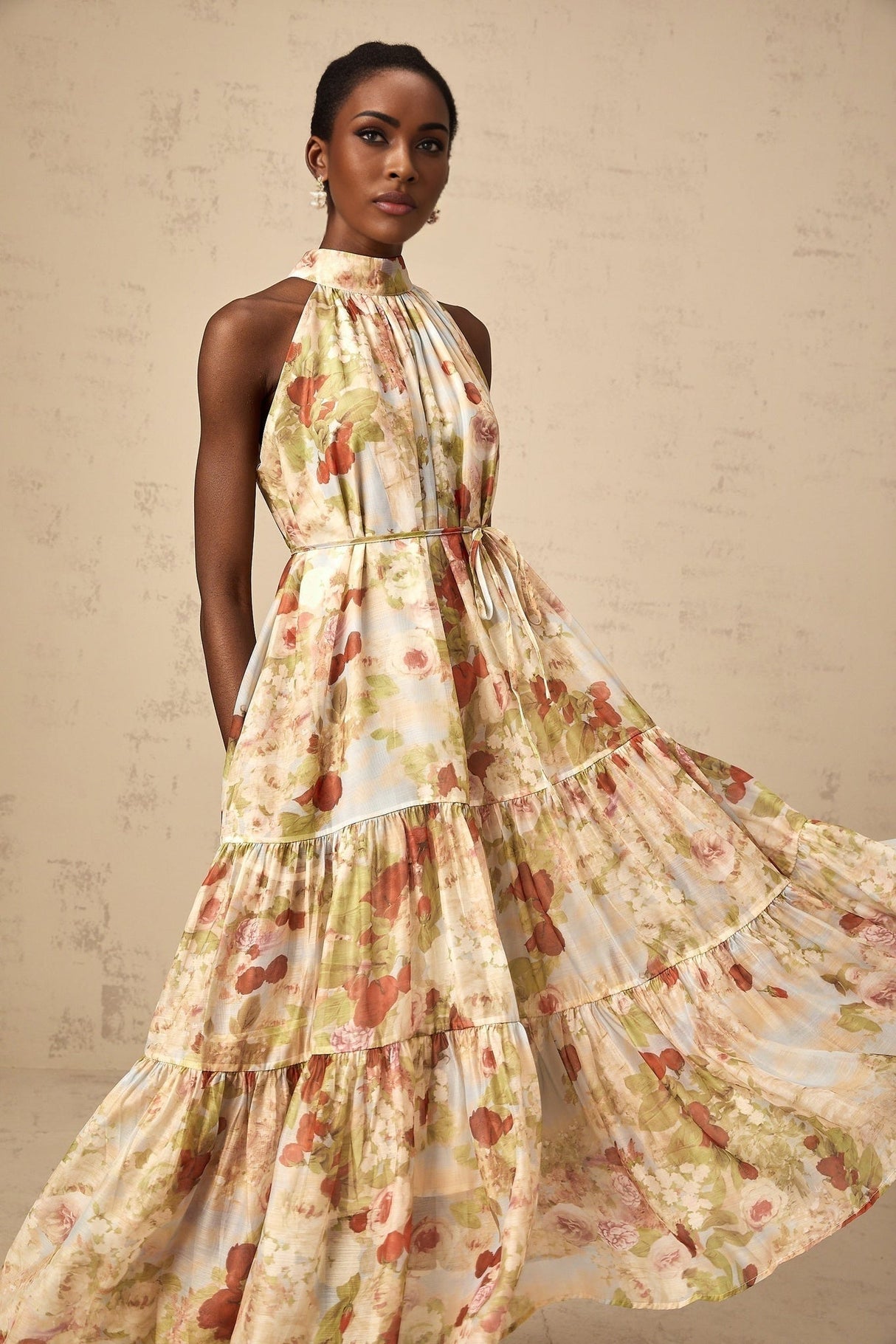 A sleeveless midi dress with a floral print pattern in neutral colors