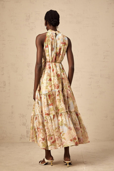 A sleeveless midi dress with a floral print pattern in neutral colors