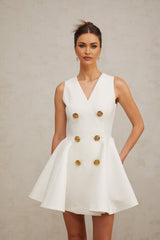 A sleeveless mini dress with a pleated peplum hem named Elise featuring a fitted bodice and flared skirt