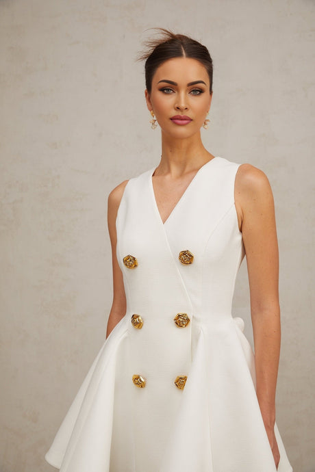A sleeveless mini dress with a pleated peplum hem named Elise