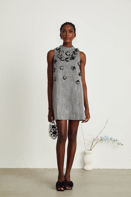A sleeveless mini dress with faux flower embellishments featuring a floral pattern and likely in pastel or vibrant colors suitable for spring or summer occasions