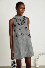 A sleeveless mini dress with vibrant faux flowers printed on the fabric featuring a floral pattern inspired design by Nadege