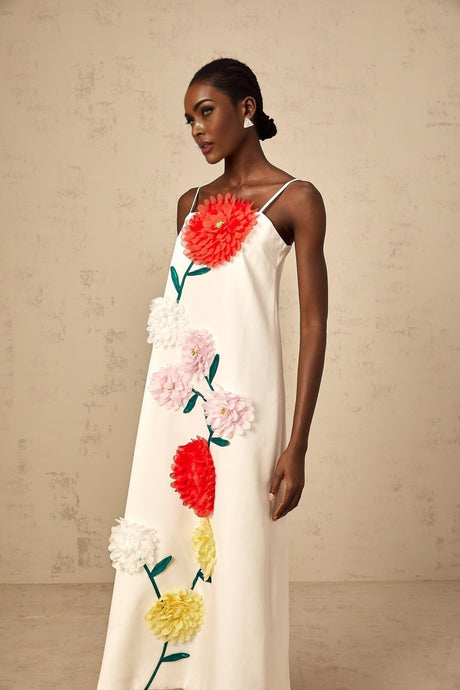 A sleeveless white midi dress with threedimensional petal details covering the bodice and skirt creating a textured floral effect