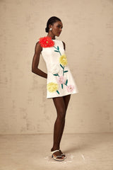 A sleeveless white mini dress with threedimensional petal details covering the bodice and skirt creating a textured floral effect