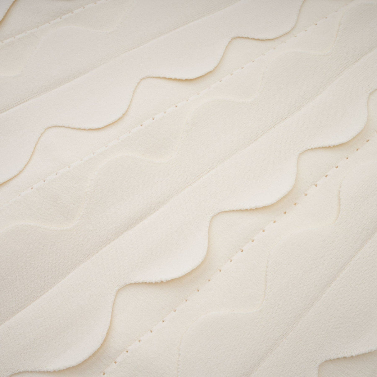 A sleeveless white mini dress with wavy details modeled on a female figure against a plain background