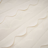 A sleeveless white mini dress with wavy details modeled on a female figure against a plain background