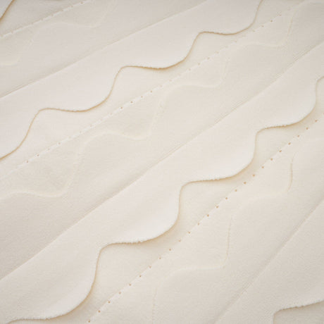 A sleeveless white mini dress with wavy details modeled on a female figure against a plain background
