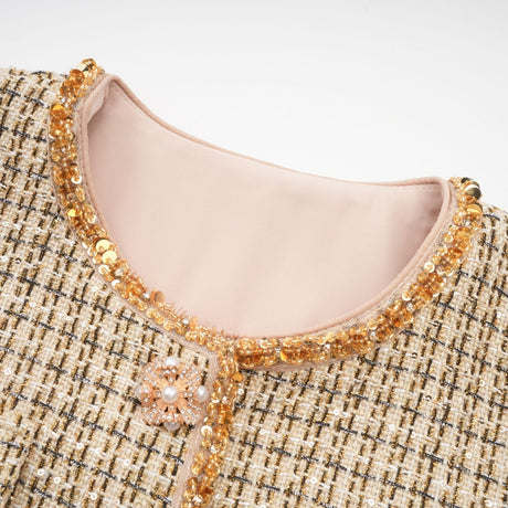 A stylish gold tweed jacket and matching skirt set with sequin embellishments creating a glamorous and coordinated outfit