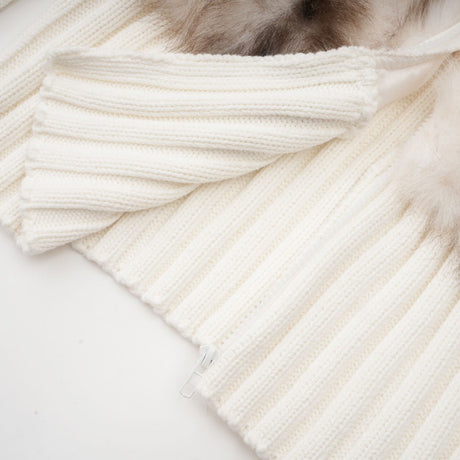 A tan colored faux fur jacket with ribbed knit detailing and a cozy oversized fit