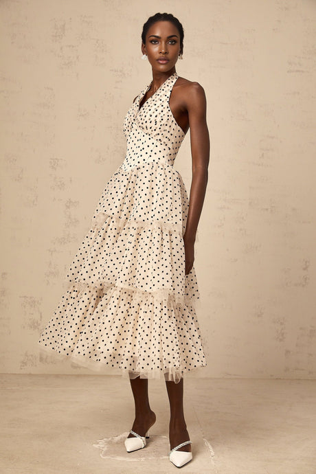 A tiered midi dress in ivory color with polka dot pattern featuring multiple layers and a midlength hemline