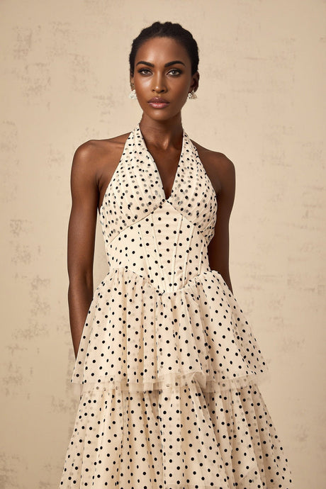 A tiered midi dress in ivory fabric with polka dot pattern featuring multiple layered ruffles