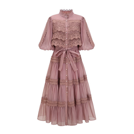 A tiered midi dress with lace cutouts featuring a light and airy design in white or cream color with intricate patterns and a flowy silhouette