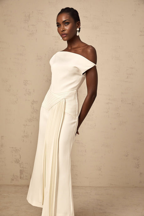 A white asymmetric midi dress with draped fabric details worn by a model standing against a plain background