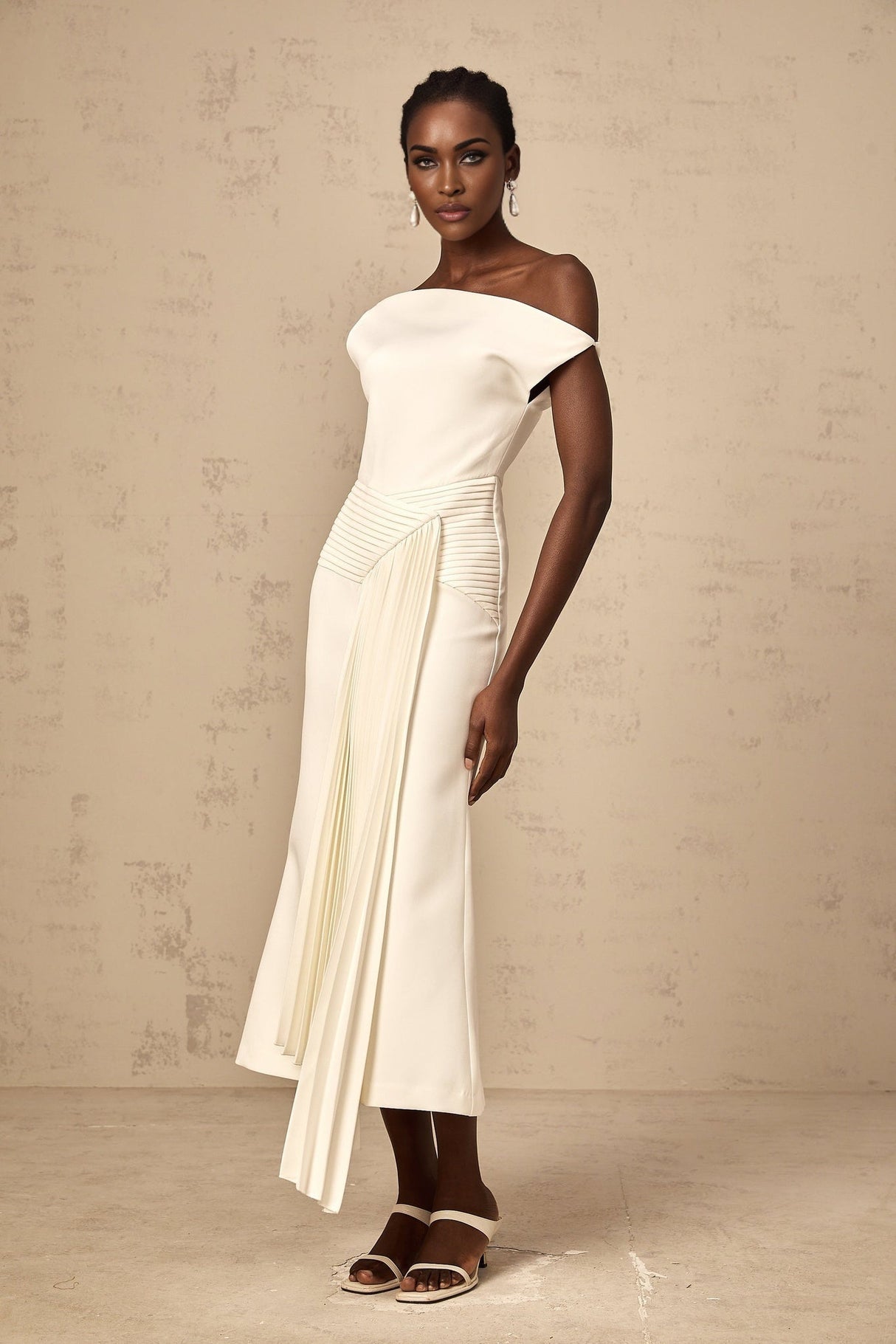 A white asymmetric midi dress with draped fabric details worn by a model standing against a plain background