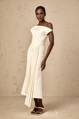 A white asymmetric midi dress with draped fabric details worn by a model standing against a plain background