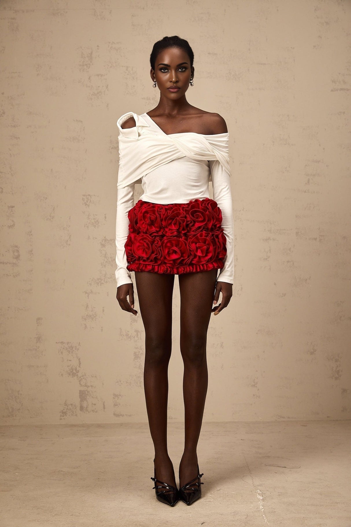A white asymmetric top with twisted jersey fabric featuring a unique neckline and draping design