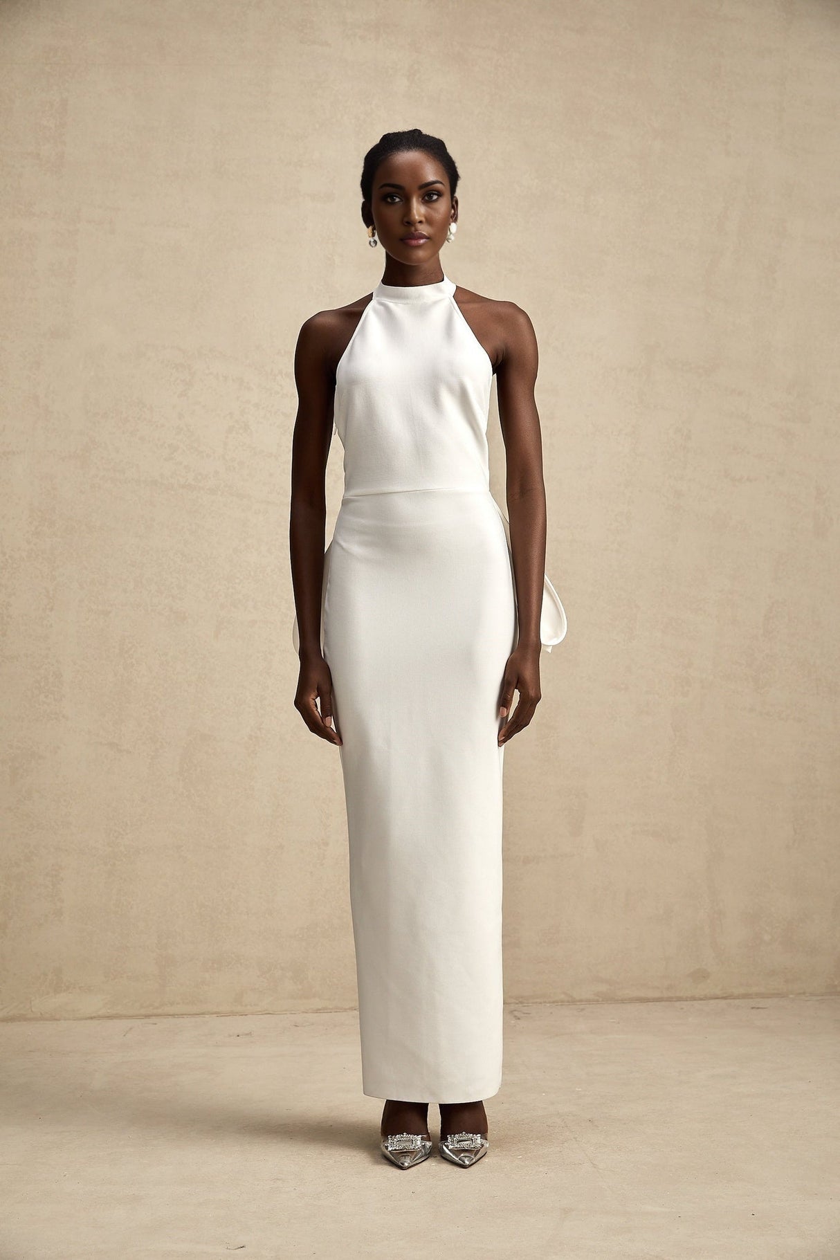 A white bandage dress with an oversized bow detail featuring a fitted silhouette and Capucine style design