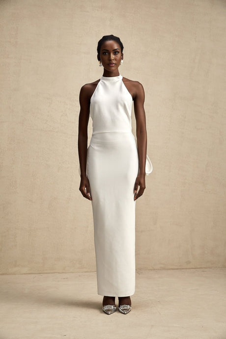 A white bandage dress with an oversized bow detail featuring a fitted silhouette and Capucine style design