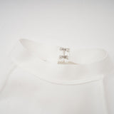 A white bandage dress with an oversized bow detail featuring a fitted silhouette and Capucine style