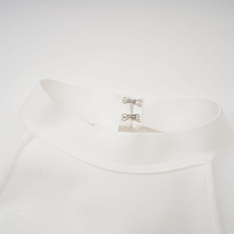 A white bandage dress with an oversized bow detail featuring a fitted silhouette and Capucine style