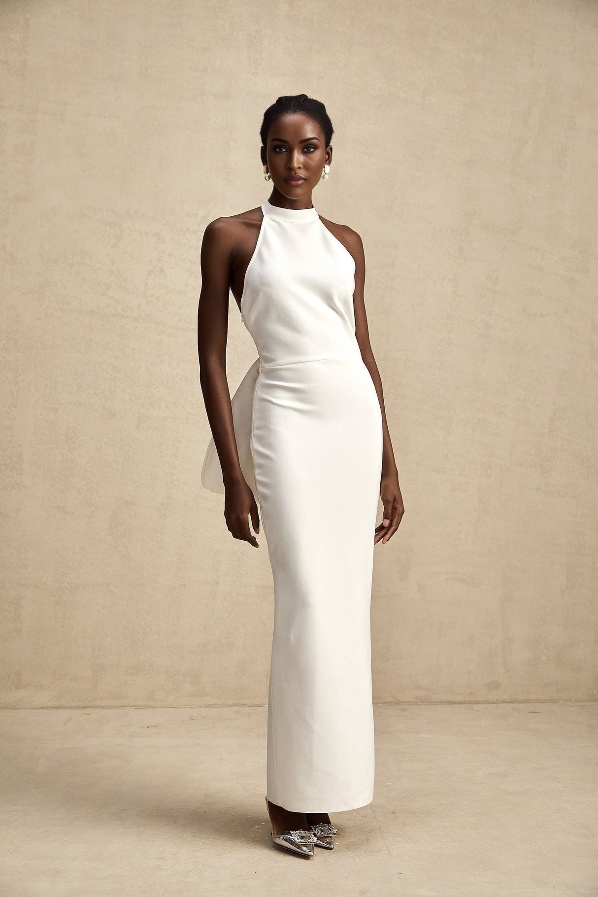 A white bandage dress with an oversized bow detail featuring a fitted silhouette and named Capucine