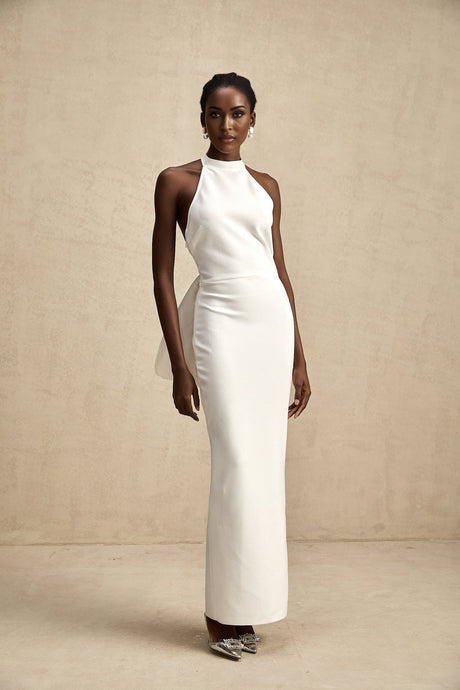 A white bandage dress with an oversized bow detail featuring a fitted silhouette and named Capucine