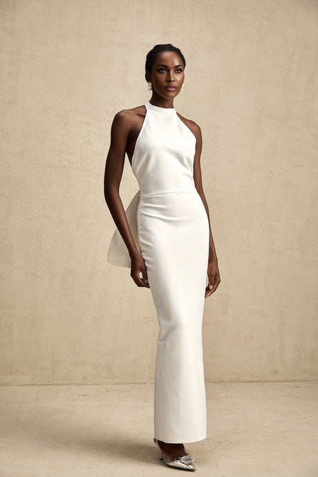 A white bandage dress with an oversized bow detail named Capucine featuring a formfitting silhouette and elegant design