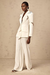 A white blazer and trouser set with butterfly applique embellishments on both pieces The blazer features a tailored fit while the trousers have a slim cut Both garments are adorned with delicate white butterfly designs creating an elegant and ethereal look