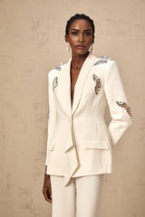 A white blazer and trousers set featuring delicate butterfly appliques and embellishments creating an elegant and ethereal look