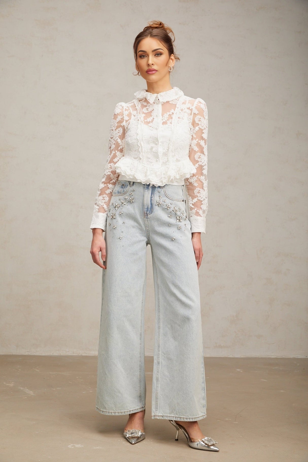 A white blouse with delicate floral embroidery and lace detailing named Karine