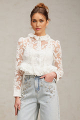 A white blouse with floral embroidery and lace details featuring a delicate pattern on a lightweight fabric