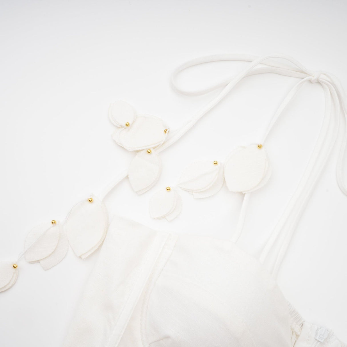 A white corset style midi dress with a fitted bodice and flared skirt on a female model