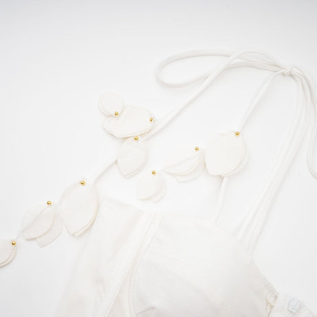 A white corset style midi dress with a fitted bodice and flared skirt on a female model