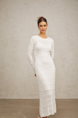 A white crochet knit midi dress with a flowing silhouette and intricate lace pattern