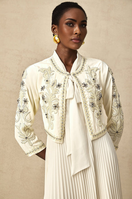 A white embellished jacket and dress set featuring a pleated design The jacket is paired with a matching dress creating an elegant ensemble