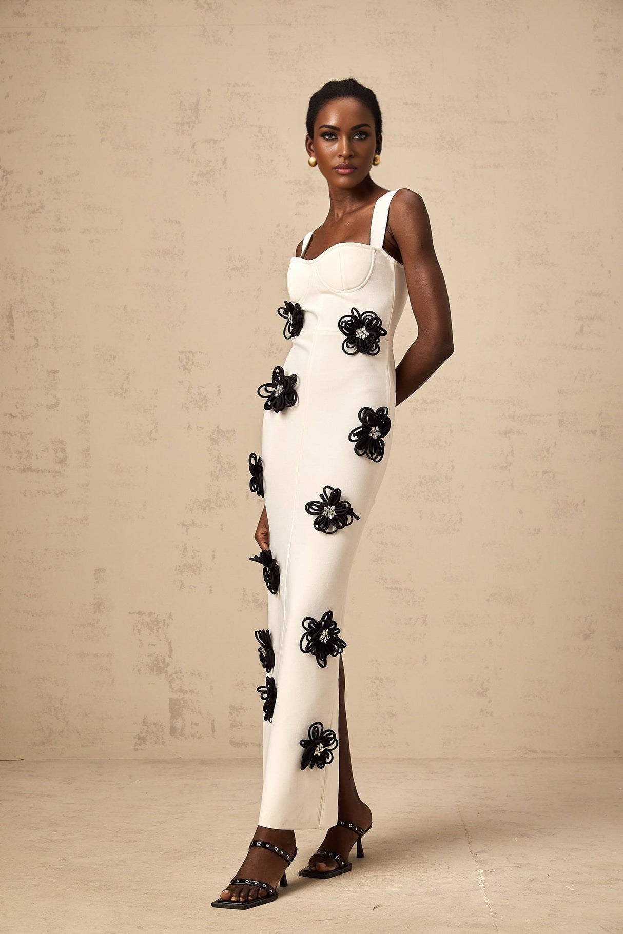 A white floorlength bandage dress with floral applique details named Olivia