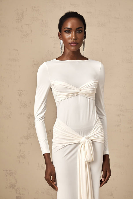 A white floorlength maxi dress with ruched fabric and a ribbon twist detail