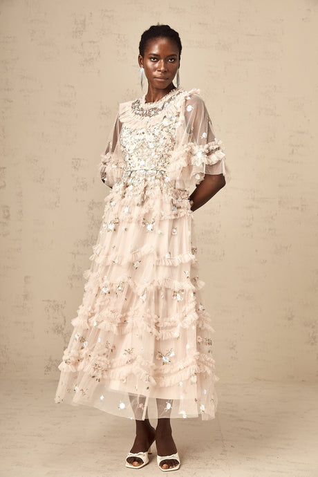 A white floral embroidered midi dress with tiered ruffles and a fitted waist featuring delicate floral patterns throughout the fabric