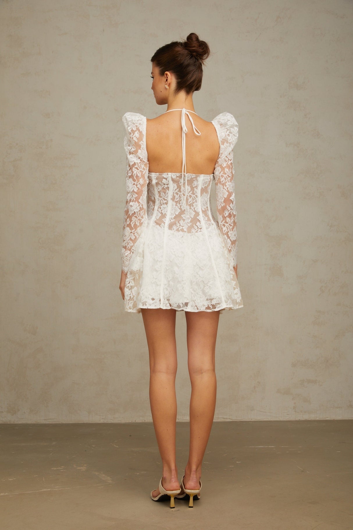A white floral lace mini dress with a corset style bodice featuring a sweetheart neckline and short skirt
