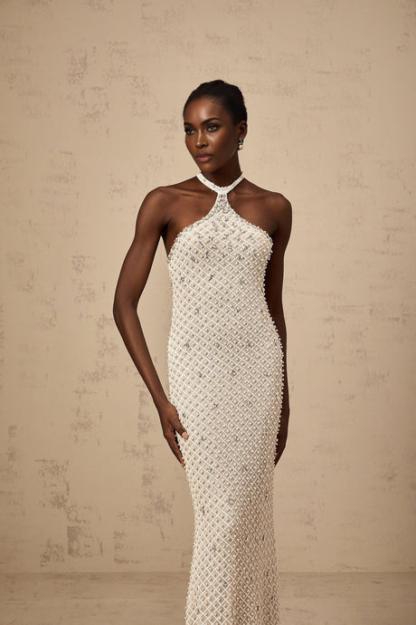 A white halterneck maxi dress with embellishments named Claudine featuring a long flowing skirt and elegant neckline