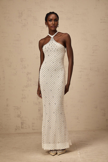A white halterneck maxi dress with embellishments named Claudine featuring a long flowing skirt and sleeveless design
