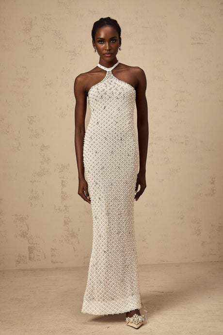 A white halterneck maxi dress with embellishments named Claudine featuring a long flowing skirt and sleeveless design