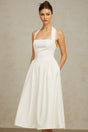 A white halterneck midi dress with pleated details and a fitted silhouette worn by a model against a plain background