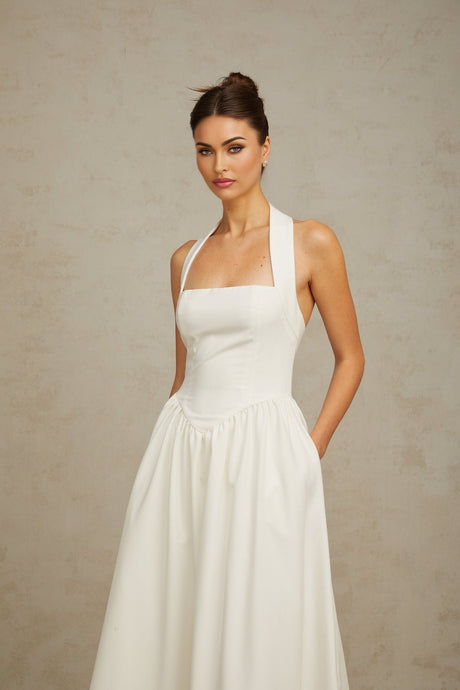 A white halterneck midi dress with pleated details featuring a sleek and elegant design