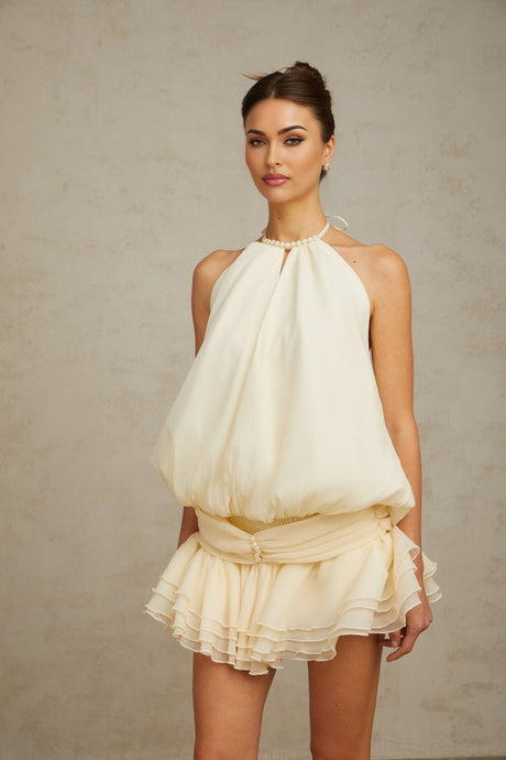 A white halterneck mini dress with faux pearl embellishments called Berenice