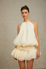 A white halterneck mini dress with faux pearl embellishments named Berenice
