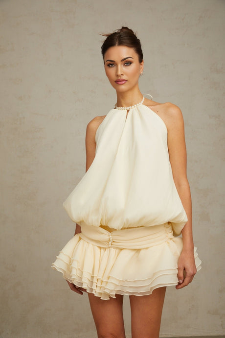 A white halterneck mini dress with faux pearl embellishments named Berenice