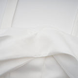 A white halterneck mini dress with ruffled details named Olivia worn by a model against a plain background